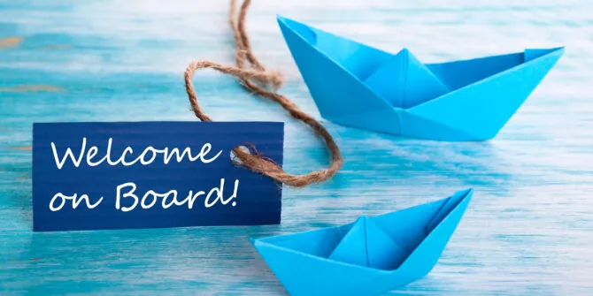 Welcome On Board tag with 2 blue paper boats.